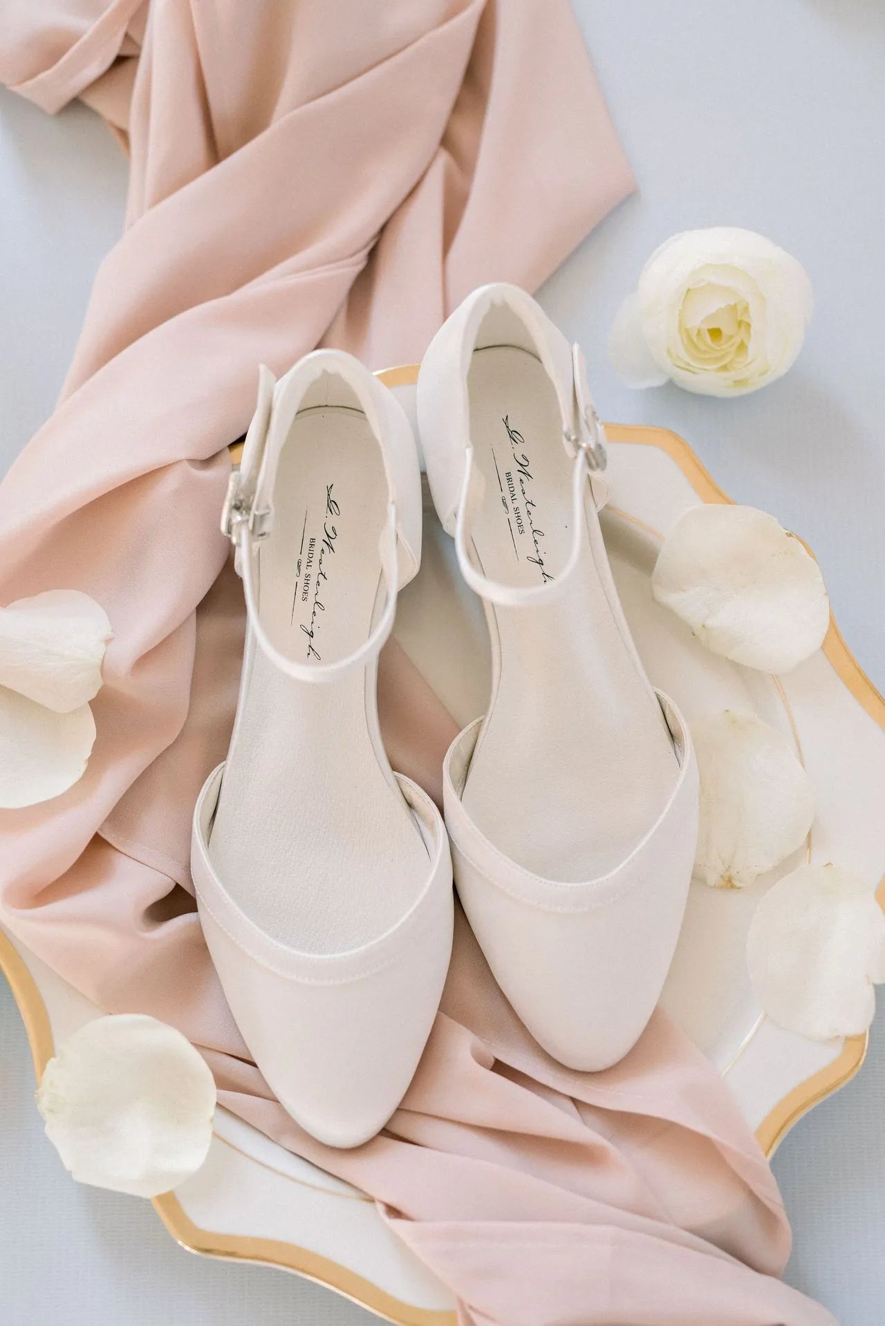 Bailarinas de novia Lisa en satén ivory, tacón bajo de 1,6 cm, con plantilla de cuero acolchada y correa ajustable para mayor estabilidad y comodidad.