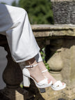 Sandalias de novia Birdie en cuero marfil con plataforma gruesa, tacón ancho de 10 cm y tiras plisadas cruzadas para un estilo elegante y cómodo.