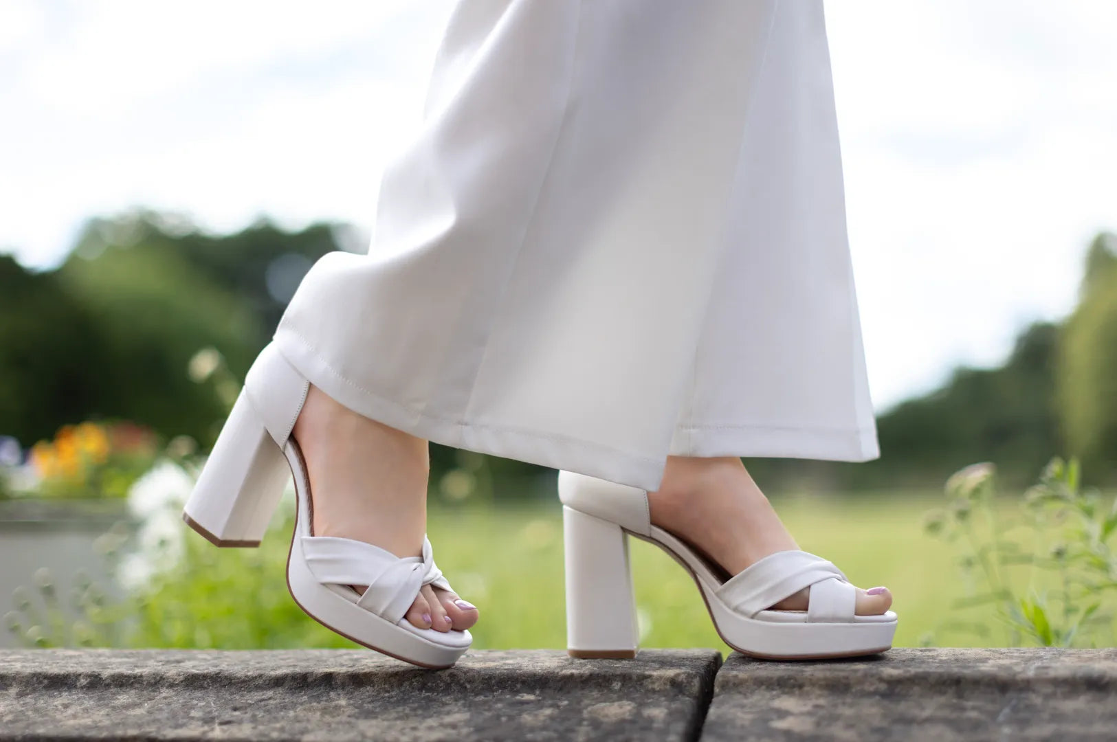 Sandalias de novia Birdie en cuero marfil con plataforma gruesa, tacón ancho de 10 cm y tiras plisadas cruzadas para un estilo elegante y cómodo.