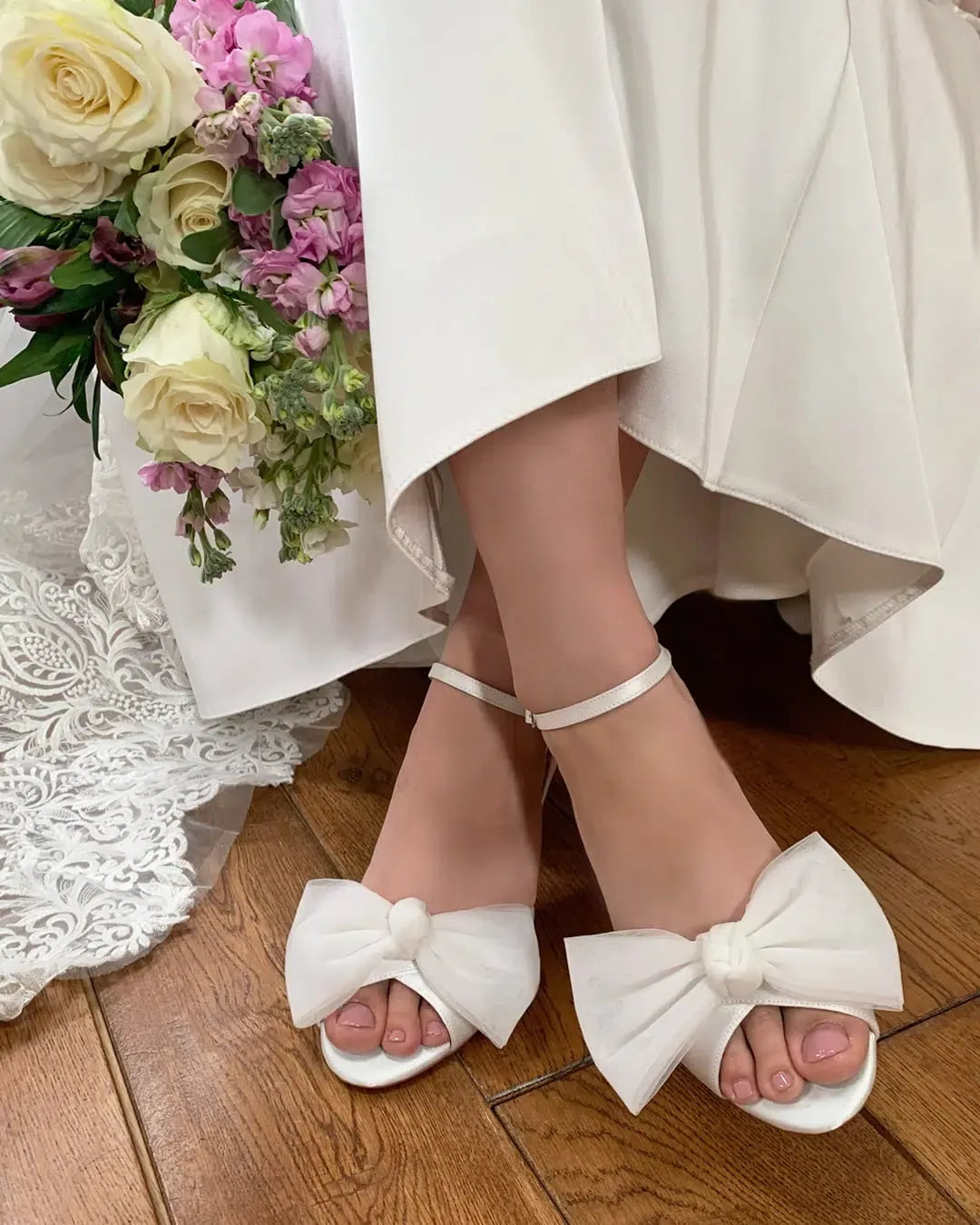 Sandalias de novia Georgia en satén marfil con tiras cruzadas, tacón bloque de 7 cm y lazo de tul desmontable para un look elegante y versátil.