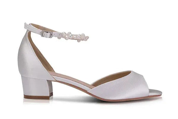 Zapatos de novia Fiona en satén marfil con puntera peep toe, sandalia tacón bajo de 3,8 cm y pulsera de perlas keshi para un look elegante y cómodo.