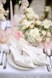 Zapatos de novia Juliet en satén ivory con adorno de rosa, tacón de 7,5 cm, elegantes y cómodos para un look sofisticado y romántico.