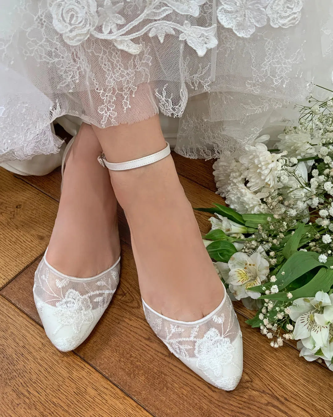 Zapatos de novia London en encaje floral marfil semitransparente y satén, con tacón bajo de bloque y correa ajustable para un look romántico y cómodo.