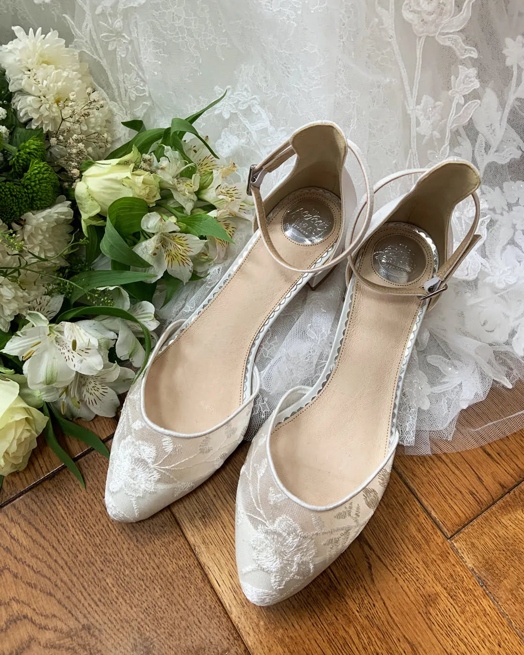 Zapatos de novia London en encaje floral marfil semitransparente y satén, con tacón bajo de bloque y correa ajustable para un look romántico y cómodo.